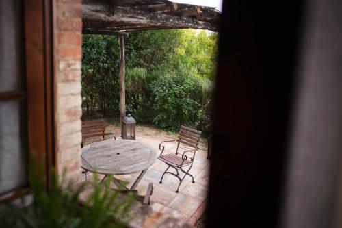 a patio with a table and chairs and an umbrella at Villa Montecastello in Monteriggioni