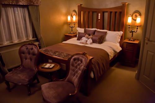 a bedroom with a bed, chair, lamp, and a dresser at The Plough Inn in York