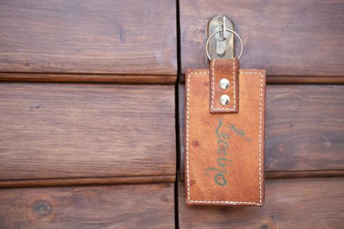 a wooden door with a leather door tag on it at Villa Montecastello in Monteriggioni