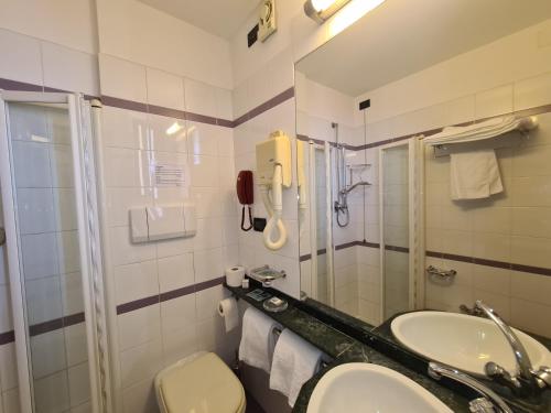 łazienka z umywalką, toaletą i telefonem w obiekcie Hotel Sabra w mieście Senigallia