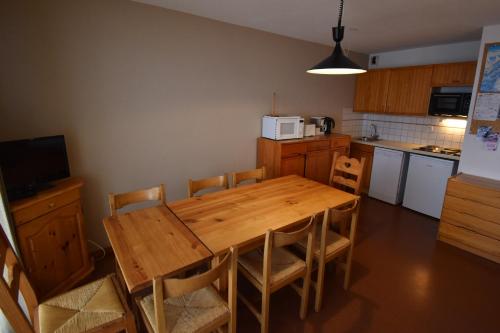 - une cuisine avec une table et des chaises en bois dans la chambre dans l'établissement VAUJANYLOCATIONS - Cochette I Apt 14, à Vaujany