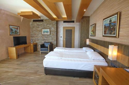 a bedroom with a large bed and a television at Art Complex Anel in Sozopol
