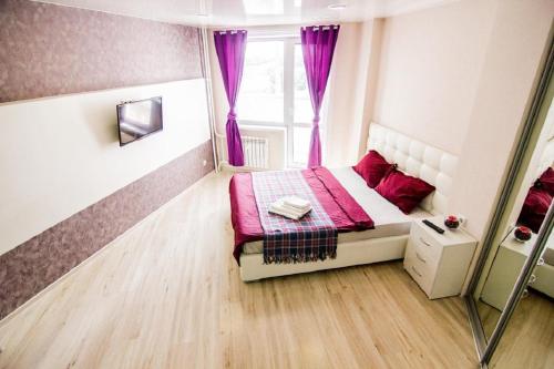 a small bedroom with a pink bed and a window at Apartment Romantic Никитина 107 in Barnaul