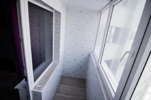 a glass shower in a bathroom with a window at Apartment Romantic Никитина 107 in Barnaul