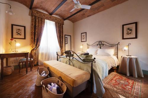 a bedroom with a bed and a table and a window at Villa Montecastello in Monteriggioni