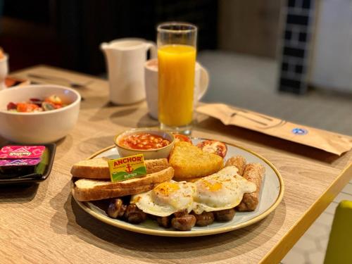 um prato de ovos e torradas e um copo de sumo de laranja em Holiday Inn London Brentford Lock, an IHG Hotel em Brentford