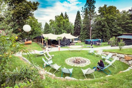 a woman sitting in lawn chairs in a garden at ClamLive Lodge in Klam