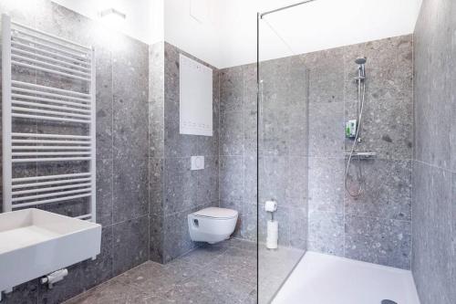 a bathroom with a shower and a toilet and a sink at ClamLive Lodge in Klam