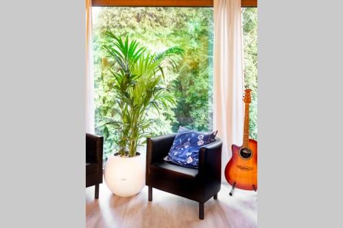 sala de estar con silla y guitarra en ClamLive Lodge, en Klam