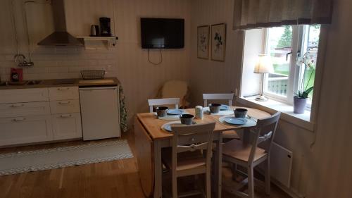 a kitchen with a table and chairs with two cups on it at Långshyttans Brukshotell in Långshyttan