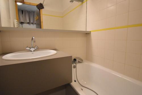 une salle de bain avec un lavabo et une baignoire dans l'établissement VAUJANYLOCATIONS - La Fare Apt 10, à Vaujany