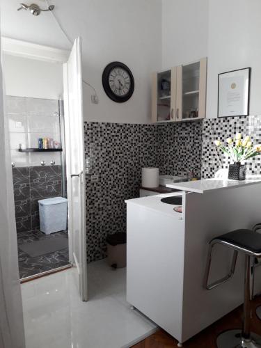 a kitchen with a refrigerator and a clock on the wall at Apartment Dunja NS in Novi Sad