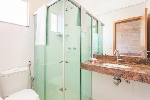 a bathroom with a glass shower and a sink at Front Hotel Expominas in Belo Horizonte