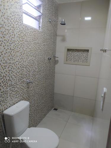 a bathroom with a white toilet and a shower at Pousada Do Sol in Parnaíba