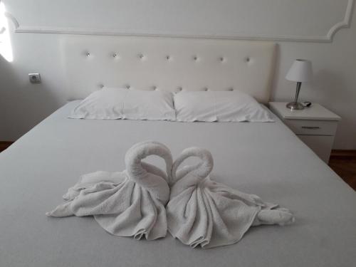 two towel swans sitting on a white bed at Apartment Dunja NS in Novi Sad