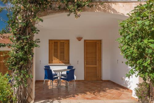 a patio with a table and chairs under an archway at Residence Bouganvillage in Budoni