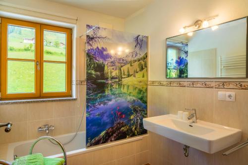 a bathroom with a sink and a painting on the wall at Mitterbichlhof in Sankt Johann im Pongau