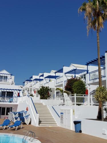 a white building with stairs and a swimming pool at Atlantis Las Lomas in Puerto del Carmen