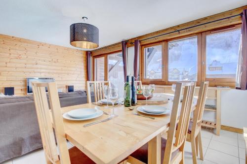 a dining room with a wooden table and chairs at Slalom Apartment - Very Town Centre - Snow and Trek - Morzine in Morzine