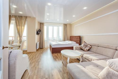 ein Wohnzimmer mit einem Sofa und einem Bett in der Unterkunft Apartments Roomer 2 in Minsk