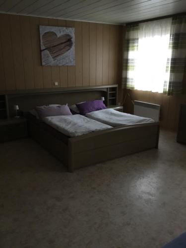 a large bed in a room with a window at Ferienwohnung Heigemeir in Ehekirchen