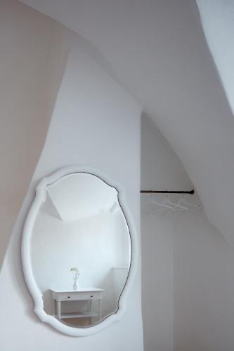 a mirror in a white room with a sink at Stará Pekárna/Old Bakery in Znojmo