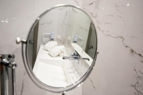 a mirror in a bathroom with a sink and towels at Lagaria Hotel in Afitos