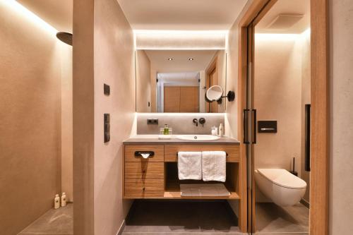 uma casa de banho com um lavatório e um WC em Giardino Marling em Marlengo