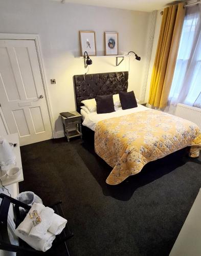 a bedroom with a large bed with a yellow bedspread at The Alb in Shrewsbury