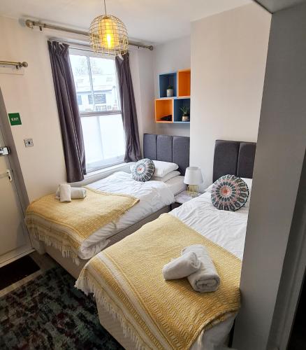 two beds in a room with a window at The Alb in Shrewsbury