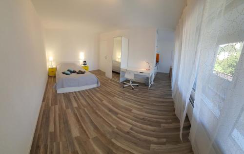 um quarto com uma cama e uma secretária num quarto em HSH Solothurn - Junior Suite LEHN Apartment in Oensingen by HSH Hotel Serviced Home em Oensingen