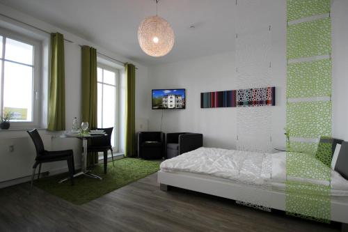 ein Schlafzimmer mit einem Bett und einem Tisch sowie ein Esszimmer in der Unterkunft Haus & Villa Seydlitz by Rujana in Binz