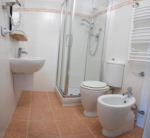 a bathroom with a shower and a toilet and a sink at Looky Hotel in Sori