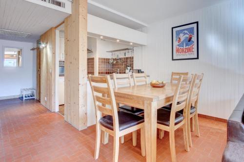 Una cocina y un comedor con mesa y sillas de madera. en Nant Crue Apartment - Snow and Trek - Morzine, en Morzine