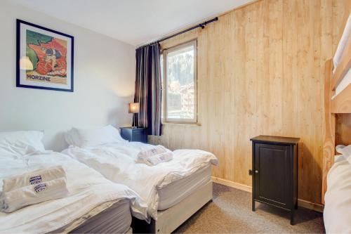 une chambre avec deux lits et une fenêtre dans l'établissement Nant Crue - Snow and Trek, à Morzine