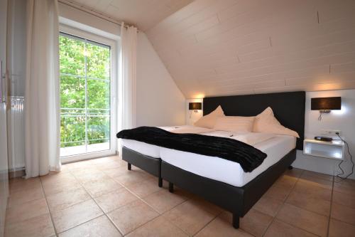 Un dormitorio con una cama grande y una ventana grande. en Ferienweingut Port, en Bernkastel-Kues