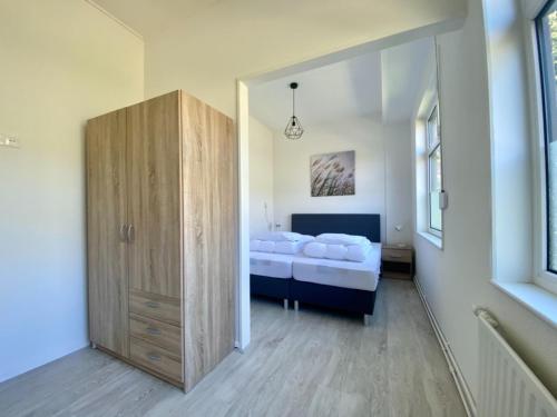 sypialnia z łóżkiem i drewnianą szafką w obiekcie Vakantiehuis Beau - Julianadorp aan Zee w mieście Julianadorp