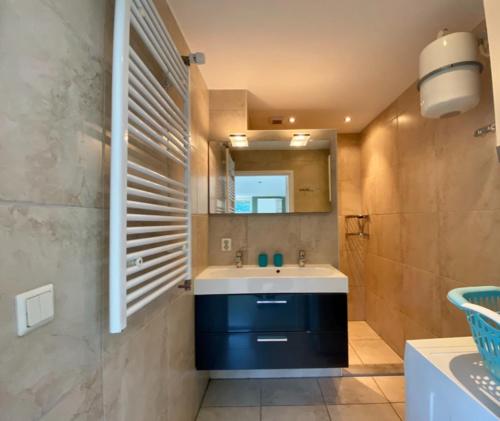 W łazience znajduje się umywalka i lustro. w obiekcie Vakantiehuis Beau - Julianadorp aan Zee w mieście Julianadorp