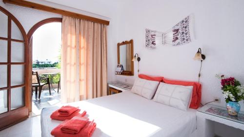 a bedroom with a white bed with red pillows on it at Olondio Apartments in Elounda