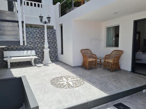 a patio with wicker chairs and a table and stairs at Pousada Ilha da Saudade in Morro de São Paulo