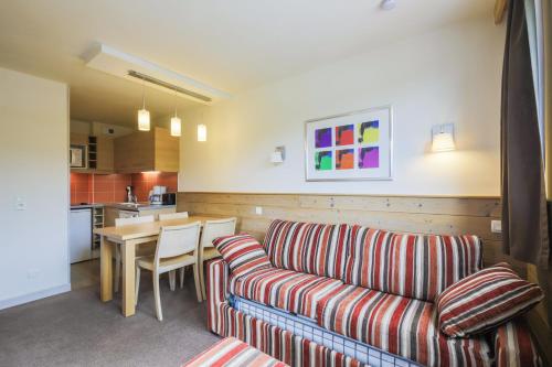 un salon avec un canapé et une table dans l'établissement Residence Les Gemeaux - maeva Home, à Belle Plagne