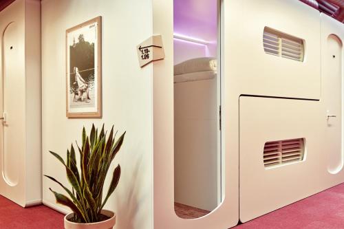 a white refrigerator in a room with a plant at CityHub Copenhagen in Copenhagen