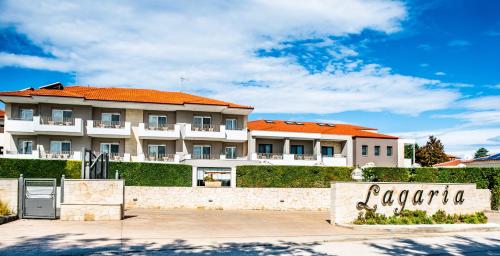 a large white building with an orange roof at Lagaria Hotel in Afitos
