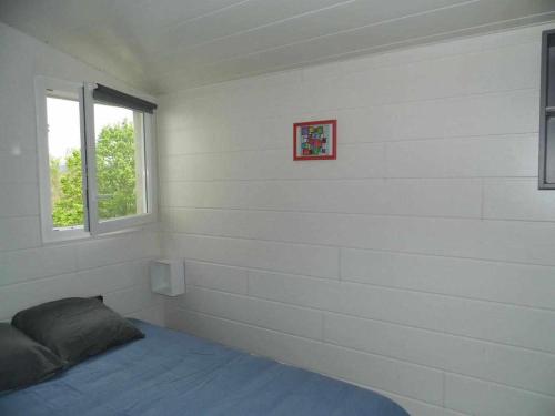 Vieille-BrioudeにあるJoli petit T2 calme au bord de leauの白い壁のベッドルーム1室、窓付きのベッド1台が備わります。