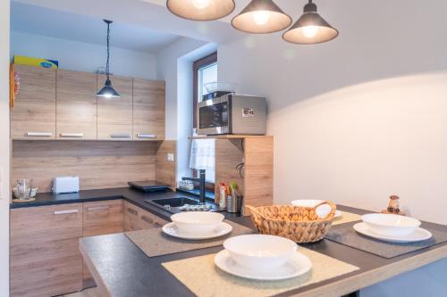 a kitchen with a counter with bowls on it at TATRYSTAY Apartment Granit 104 in Tatranská Lomnica