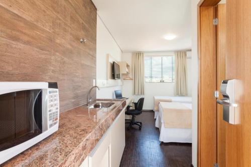 a kitchen with a counter top with a microwave at Front Hotel Expominas in Belo Horizonte