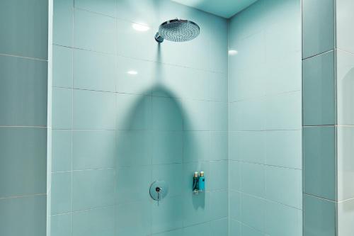 a bathroom with a shower with a shower head at CityHub Copenhagen in Copenhagen