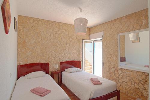 
a hotel room with two beds and two lamps at Guesthouse Peixinho in Burgau
