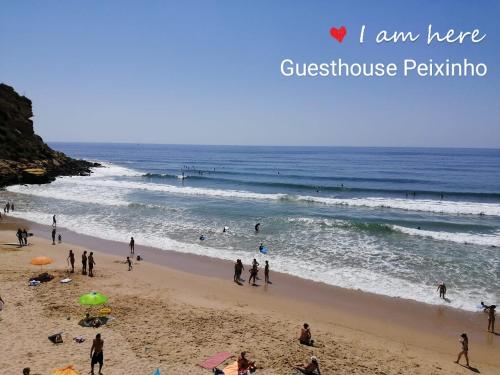 
people on the beach with surfboards at Guesthouse Peixinho in Burgau
