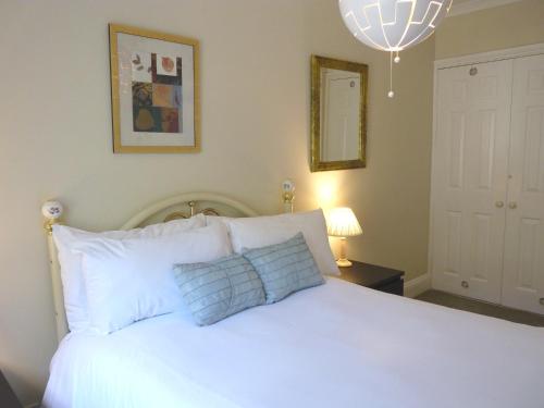 a bedroom with a white bed with blue pillows at Secret Garden Hideaway For Adults in Eastbourne